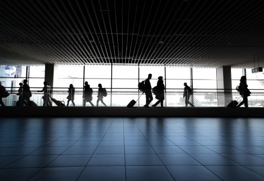 smiling student with luggage at airport shuttle pick-up